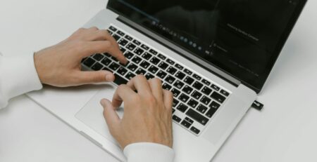 Free Hands on a Laptop Keyboard Stock Photo