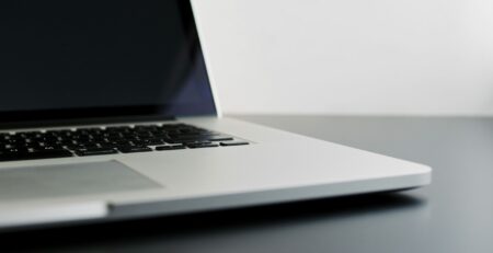 silver laptop computer on black table