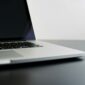 silver laptop computer on black table